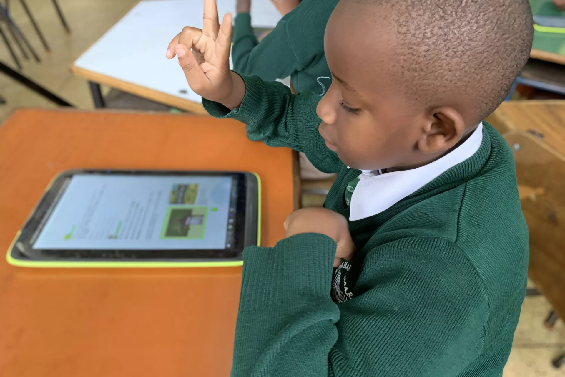 Niño sordo que aprende con un libro de texto accesible en una tableta