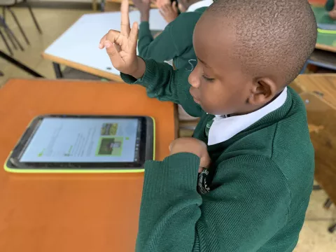 Niño sordo que aprende con un libro de texto accesible en una tableta