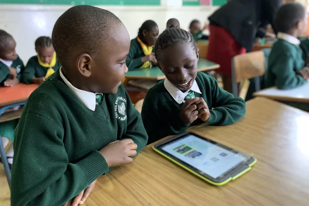 Dos estudiantes sordos que aprenden con libros de texto accesibles en un aula en Nairobi, Kenia